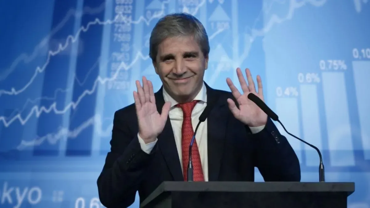 Luis Caputo en una conferencia de prensa con gráficos de deuda y mercados financieros de fondo