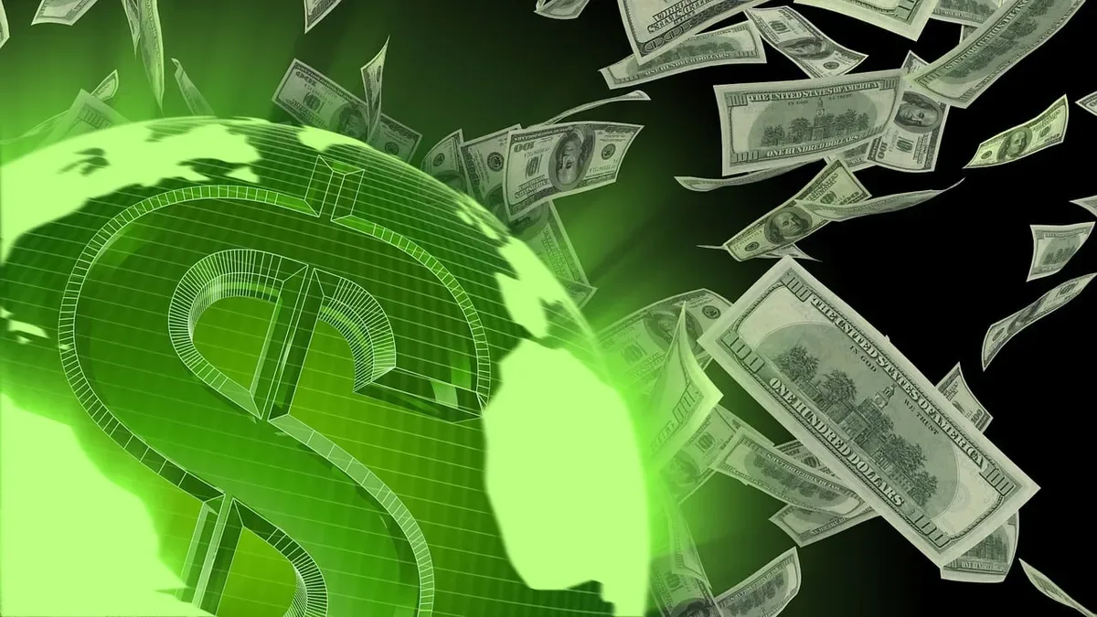 Billetes de dólar estadounidense apilados con gráficos de reservas financieras globales al fondo