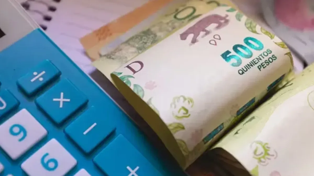 Calculadora financiera y billetes de pesos argentinos sobre un escritorio