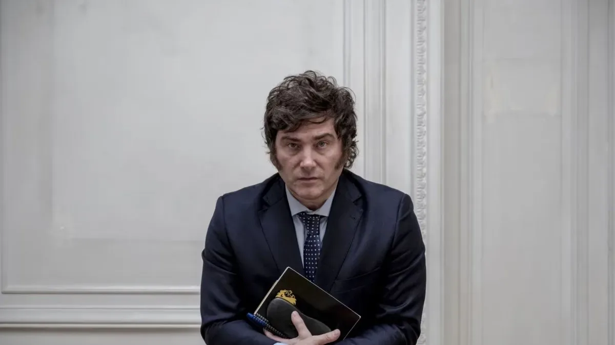 Javier Milei en un acto junto a obreros de la construcción con casco y maquinaria de fondo