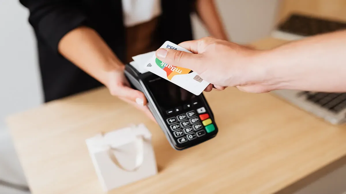 Trabajador de comercio revisando su recibo de sueldo con calculadora en mano