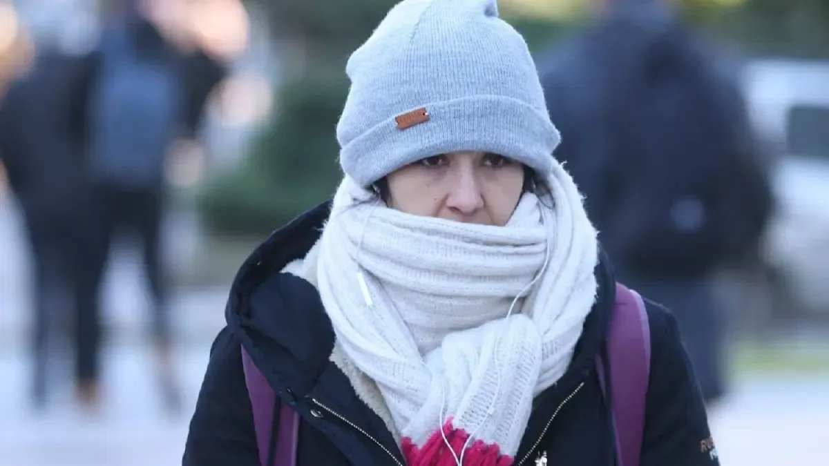 Cliente probando una campera de invierno acolchada en el pasillo de un supermercado