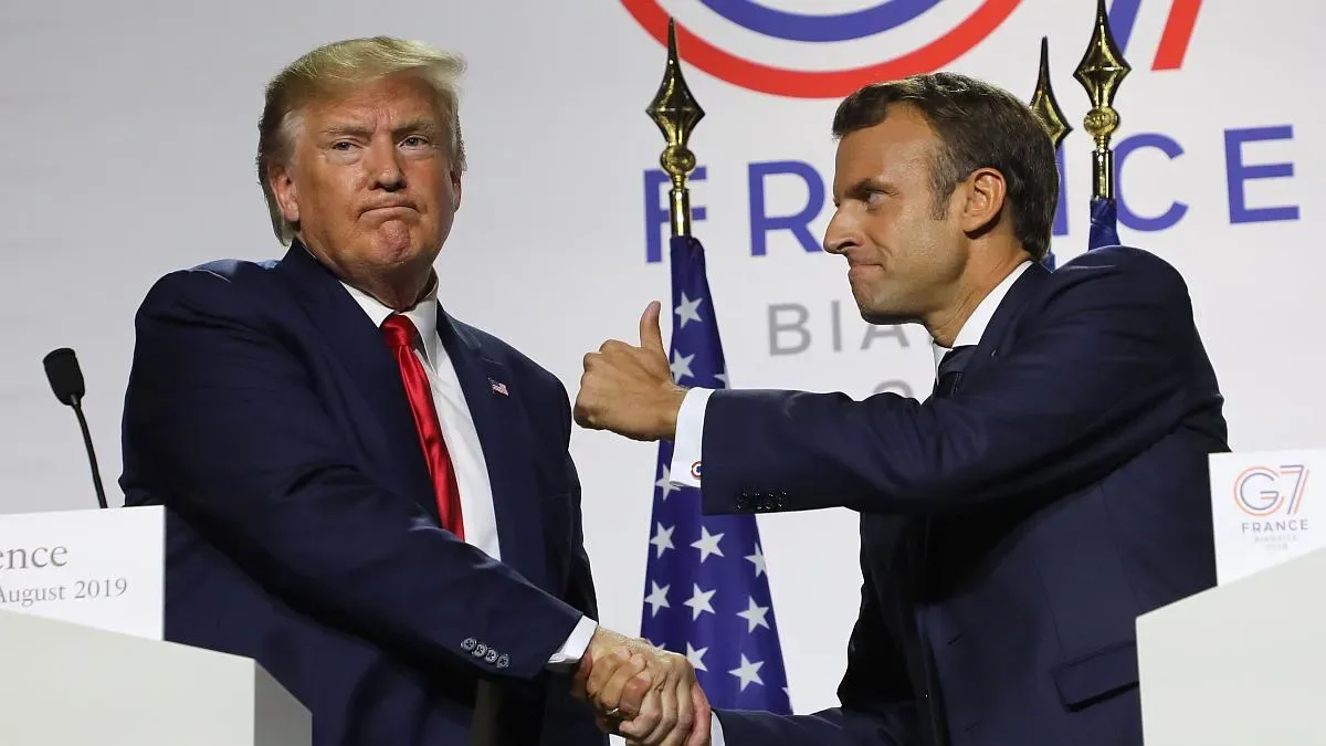 Botellas de vino y champagne francés apiladas en un estante de exportación con bandera de EEUU al fondo