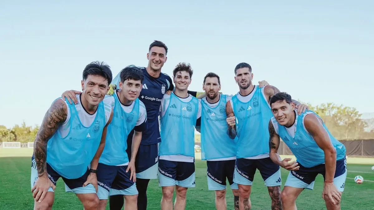 Grupo de profesionales argentinos en una oficina moderna simulando posiciones de fútbol con una pelota