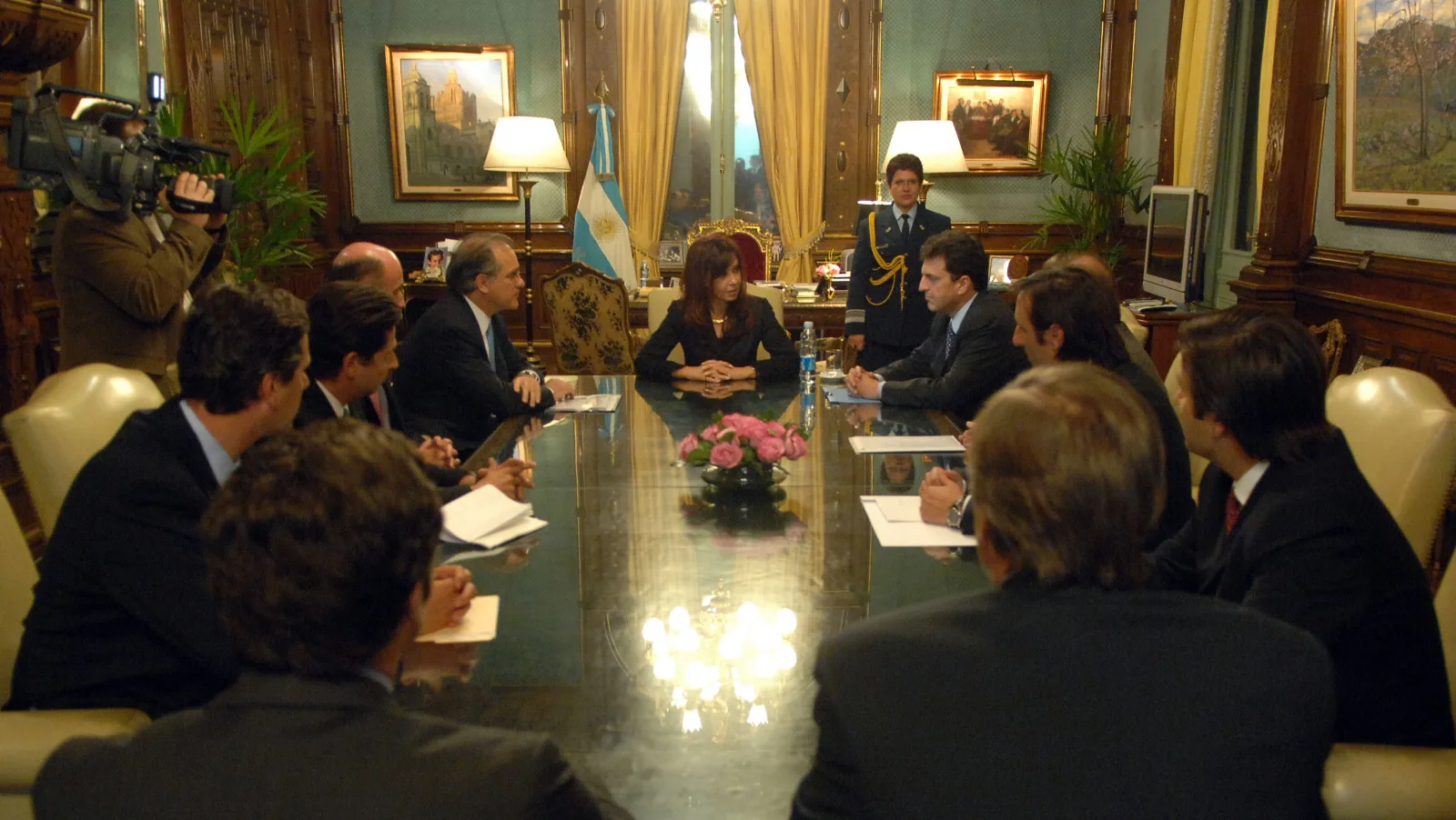 Persona revisando facturas y calculadora de deudas en una mesa de cocina en Buenos Aires