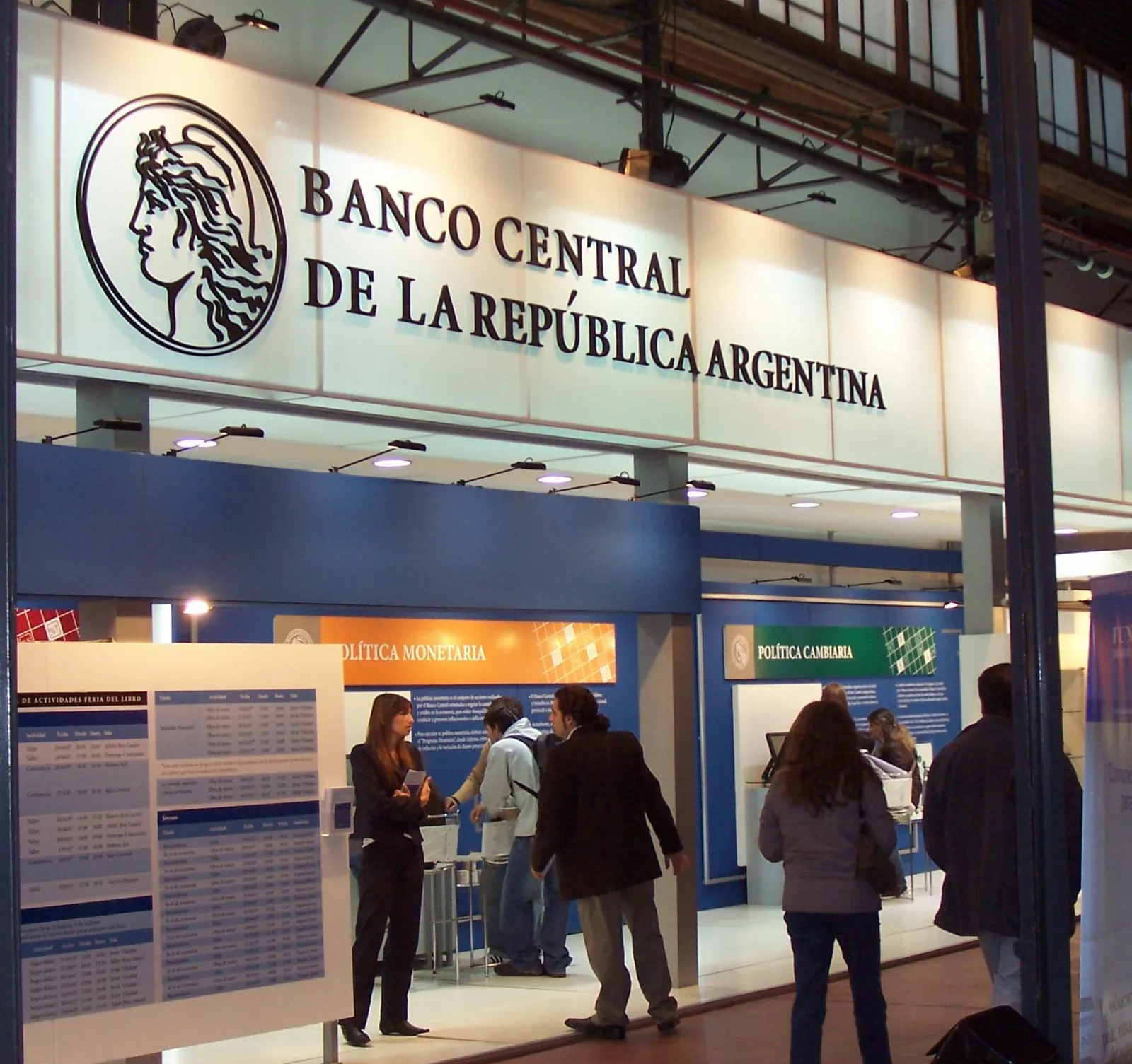 Billetes de pesos argentinos y calculadora sobre un escritorio con gráficos de tasas de interés