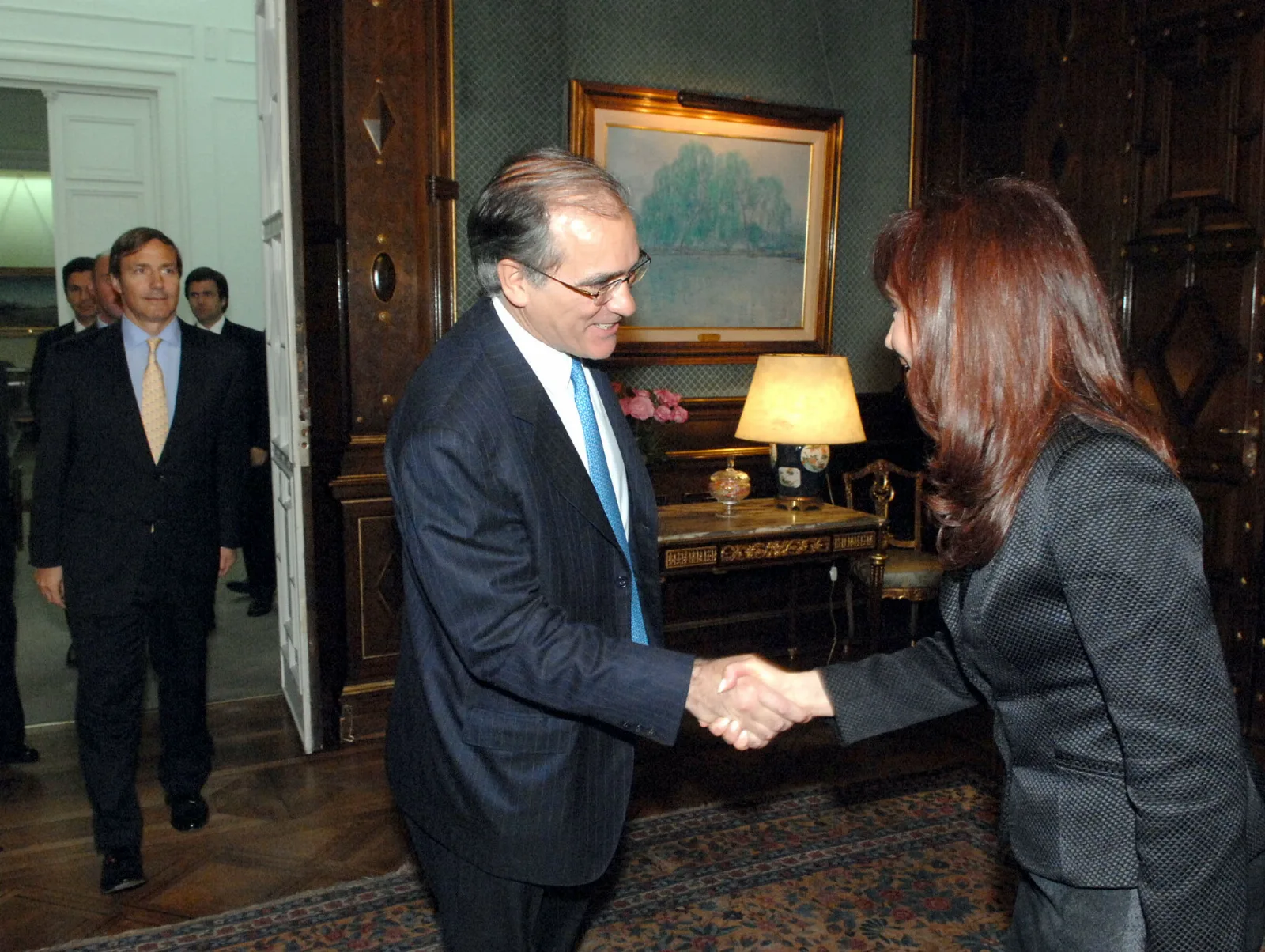 Persona revisando resumen de tarjeta de crédito con billetes de dólar y calculadora en una mesa