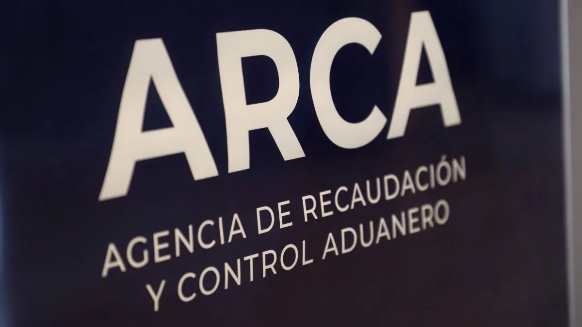 Edificio de ARCA con cartel de plazos y documentos contables en primer plano
