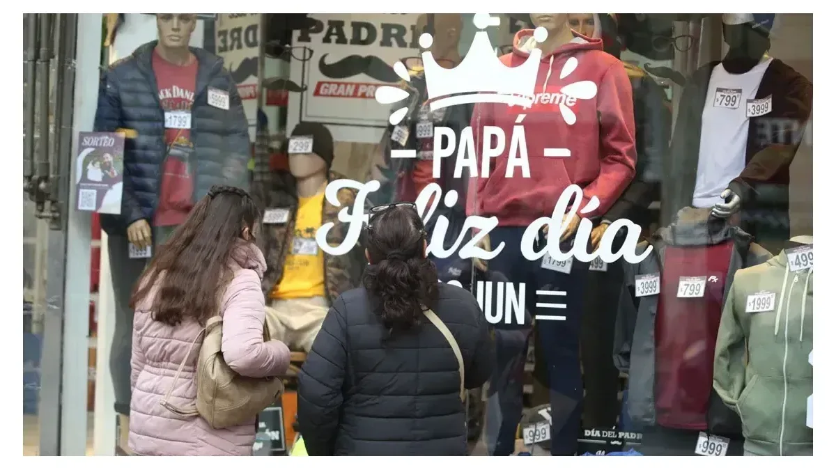 Gráfico descendente de ventas minoristas con tiendas cerradas al fondo en una calle de Buenos Aires