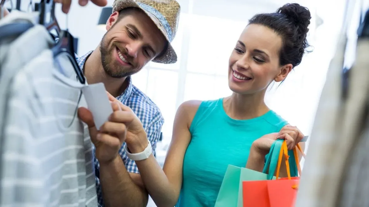 Turista cargando bolsas de compras en una avenida comercial de una ciudad estadounidense soleada