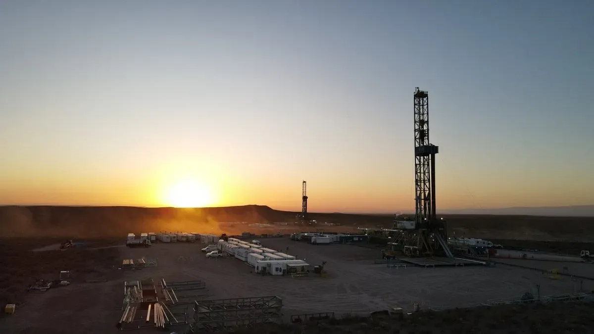 Plataforma de perforación en Vaca Muerta con torres y equipamiento al atardecer